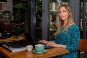 Female Executive Having Coffee In An Urban coffee shop with laptop working. Personal Branding Photography by Emma Milestone